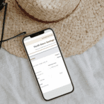 A screenshot of the thrift store saving estimator on a phone, next to a straw hat.